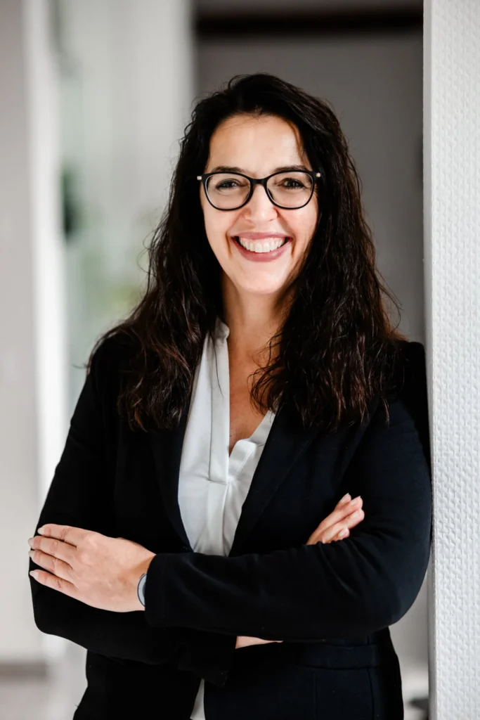 Martina Scheuring, Finanzexpertin in Trier, lehnt lächelnd an der Wand.