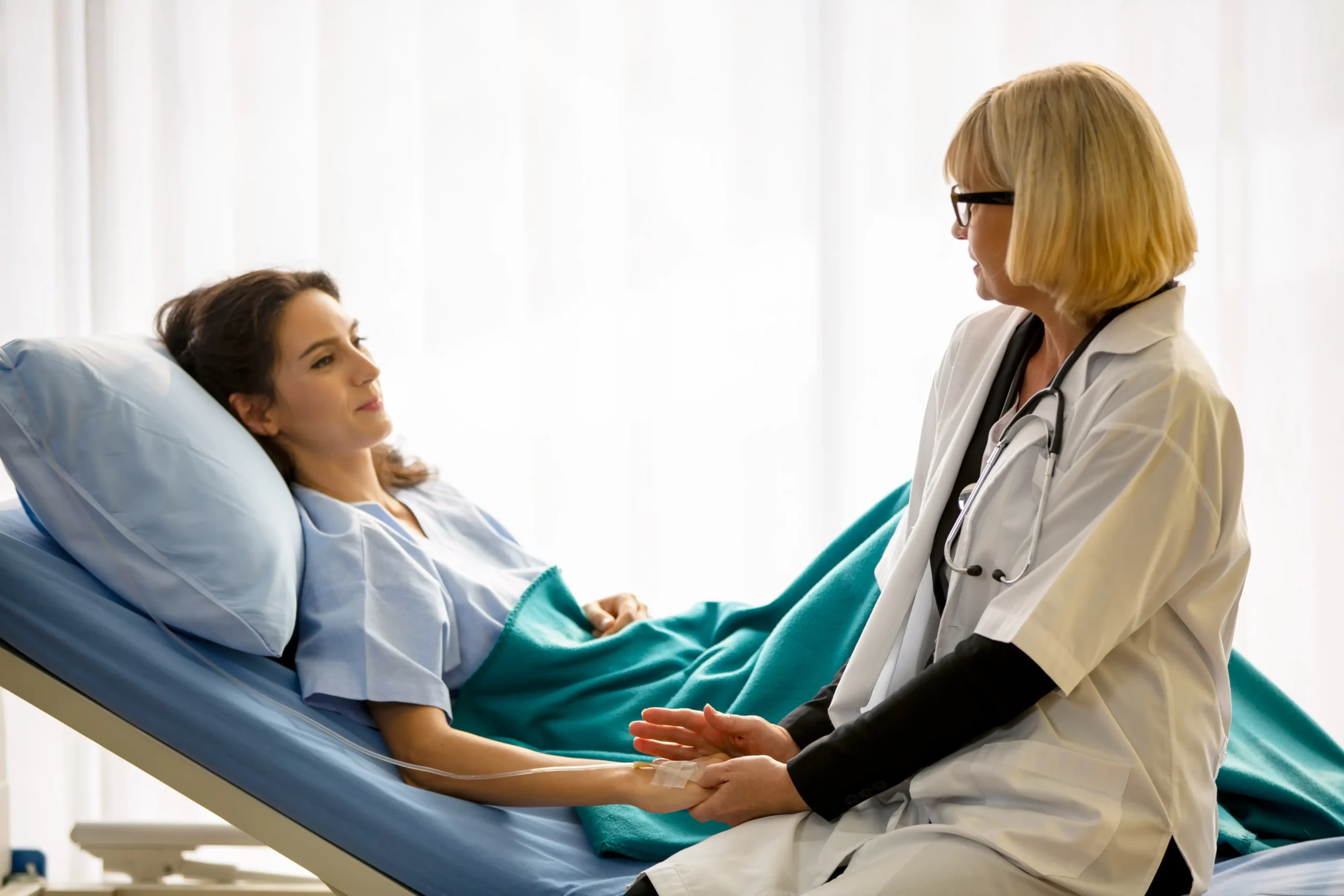 Frau liegt krank im Krankenhaus dread disease versicherung